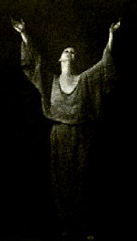 Isadora in a dark, flowing robe, her arms raised high