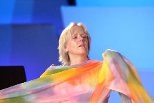 OR Melling in brightly colored scarves dancing as Guendolena during